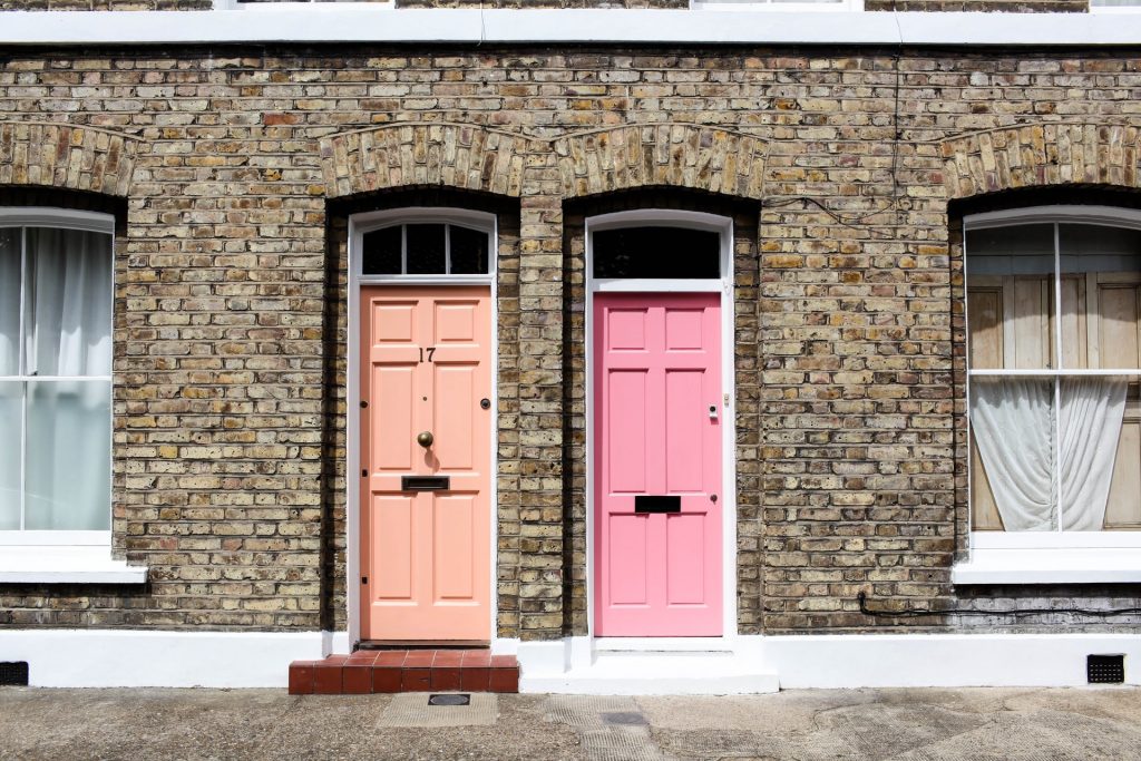 Two terrace properties, one with a peach coloured front door and the other with a pink front door. Derby based Cash Property Buyer help people sell their homes fast.